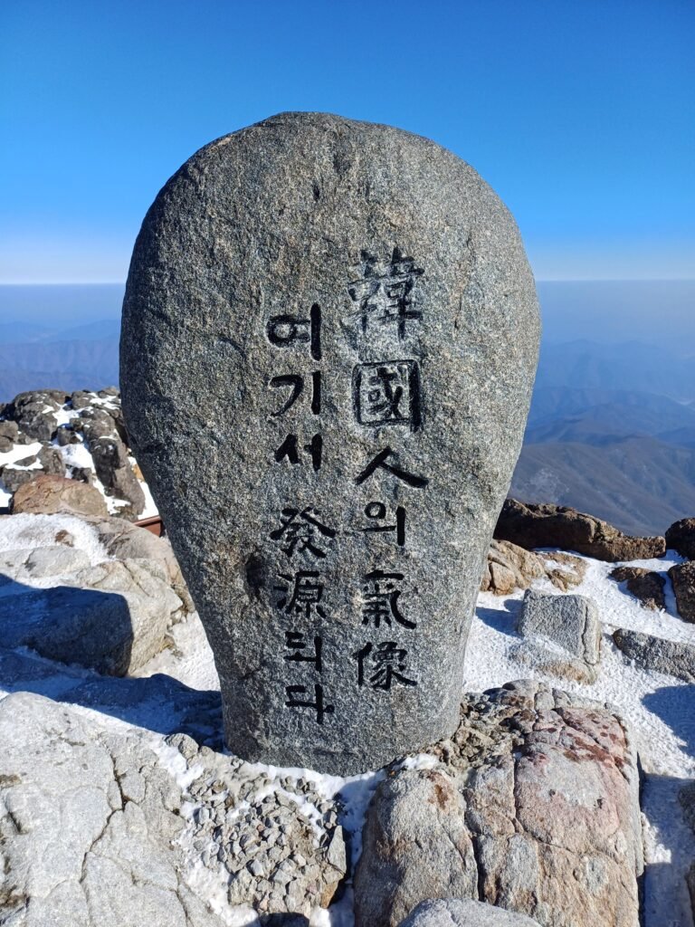 The iconic stone monument at the 1,915m summit of Cheonwangbong, inscribed with the peak's name and the famous phrase, "The Spirit of Koreans Starts Here."