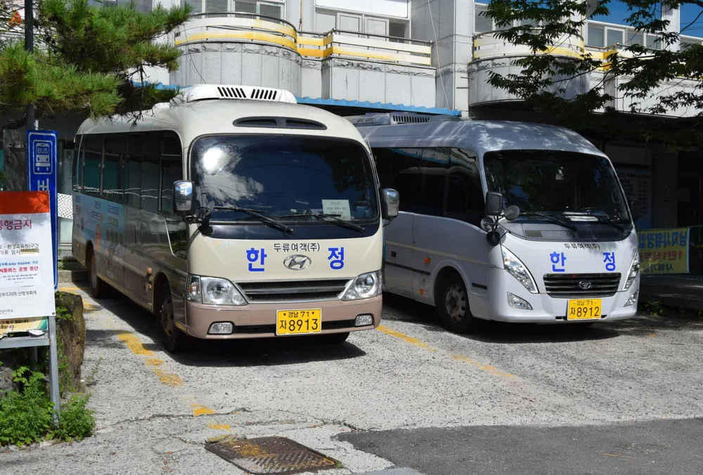 The white and blue Sunduryu shuttle bus parked at the Jungsan-ri Visitor Center, used by hikers to save energy for the steep mountain climb.