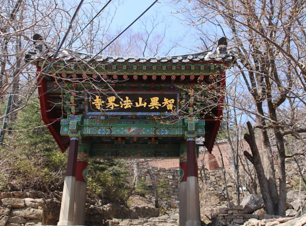 The traditional wooden Iljumun gate of Beopgyesa Temple, the highest temple in Korea, nestled peacefully in the mountain landscape.