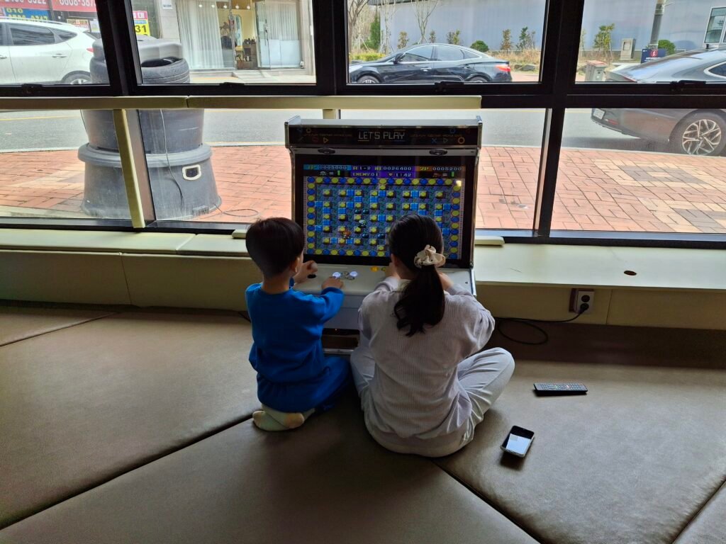 Family-friendly play zone inside the restaurant featuring floor mats and a classic Bomberman arcade game for children.